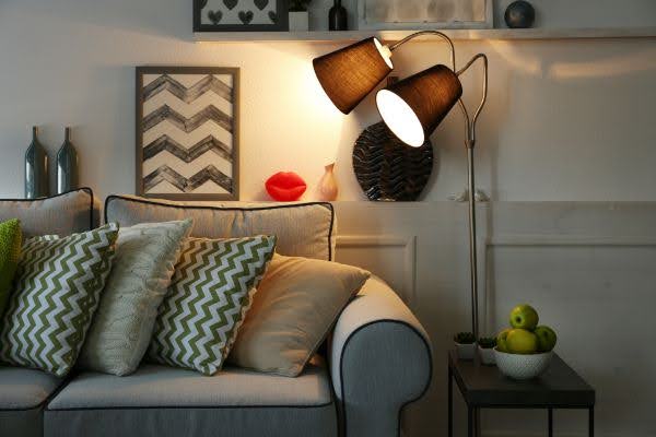 Photo of family room couch with a dimly lit lamp beside it.