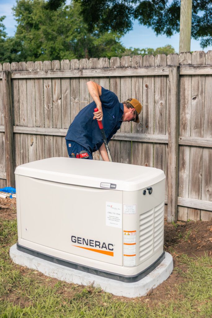 Holly Electric technician finishing the install of a whole-house standby generator on a concrete pad